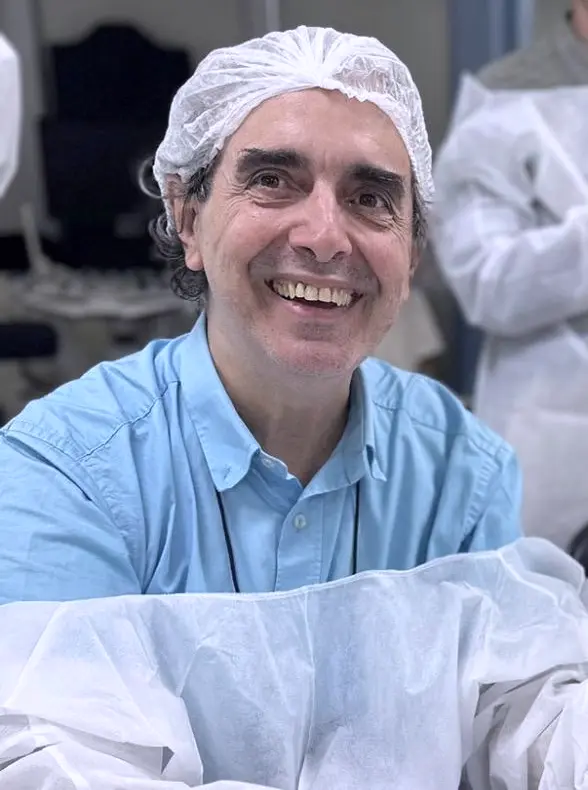 Dr. Haroldo sorrindo durante aula prática de ultrassonografia, de touca e avental descartáveis